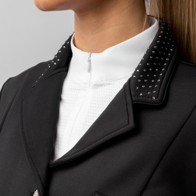 Blazer preto com botão e tachas prateadas no colarinho e camisa branca com gola alta.