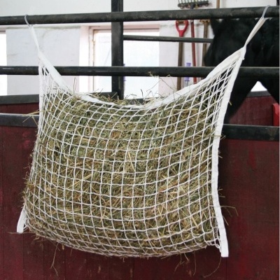 Rede branca para feno presa a barras pretas em ambiente interno com parede vermelha