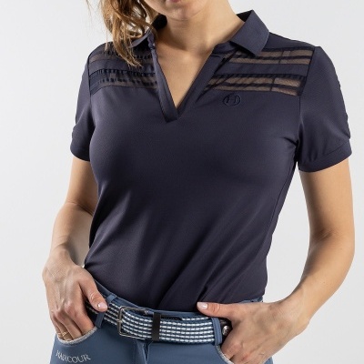 Mulher a vestir t-shirt polo azul escuro com transparências e calças azul claro com cinto de padrão xadrez