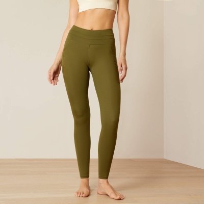 Leggings verdes justas femininas em fundo neutro com chão de madeira