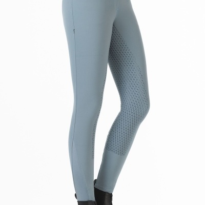 Calças justas cinza com detalhes perfurados e cinto preto.