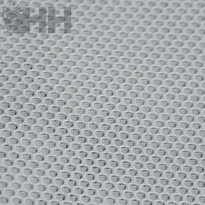Tecido branco com padrão de malha aberta em forma de colmeia