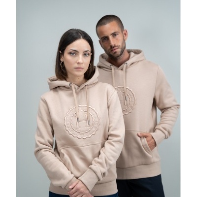 Duas pessoas com sweatshirts bege com capuz e bordado H frontal em fundo cinzento claro