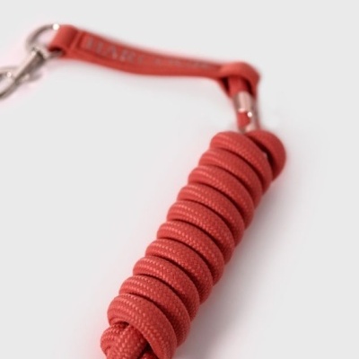 corda vermelha enrolada com gancho metálico prateado e etiqueta vermelha