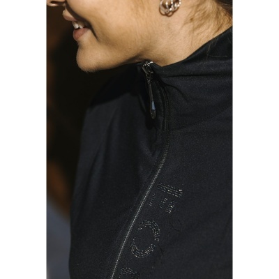 Casaco preto de mulher com fecho de correr e texto em relevo, visualizado de lado.