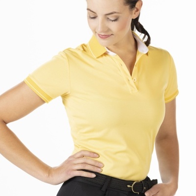 Mulher com polo amarela e calças pretas numa pose casual