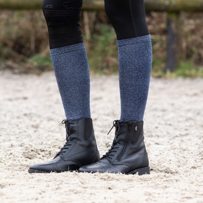 Botas pretas de couro para equitação com cadarço frontal sobre areia