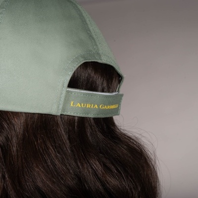 Boné verde claro de tecido com ajuste e texto amarelo LAURIA GARRELLI