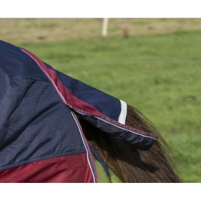 Cobertura azul escuro e bordô para cavalo na cauda, em campo verde