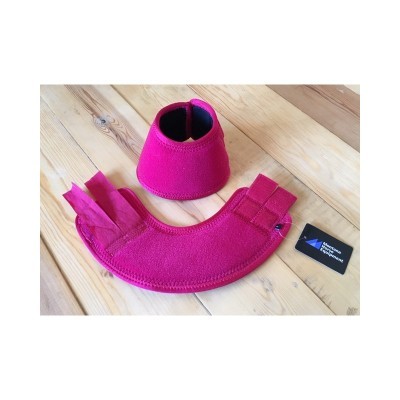 Suporte ou proteção rosa em tecido sobre piso de madeira claro com cartão preto ao lado