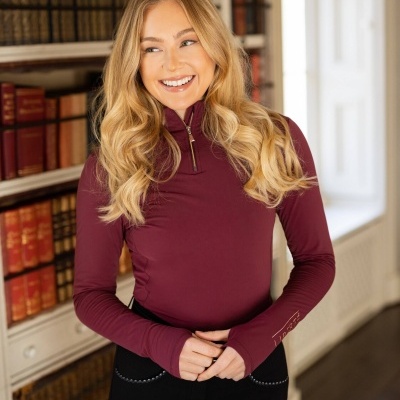 Camisola bordeaux manga comprida com fecho ao peito, ambiente com estantes de livros