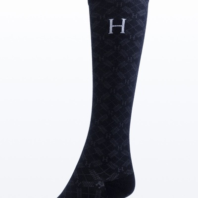 Meia preta comprida com padrão geométrico e letra H branca bordada