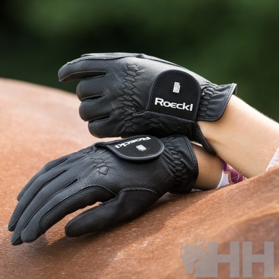 Luvas pretas Roeckl sobre cavalo castanho