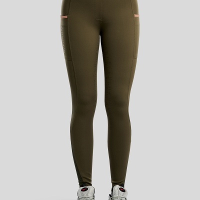 Leggings verdes oliva justas com bolsos laterais e ténis brancos e cinza.