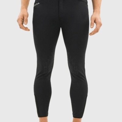 Calças justas pretas em modelo masculino, com textura e ténis brancos