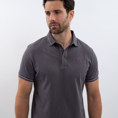 Homem com polo cinzento escuro de malha piquê com detalhes brancos na gola e mangas