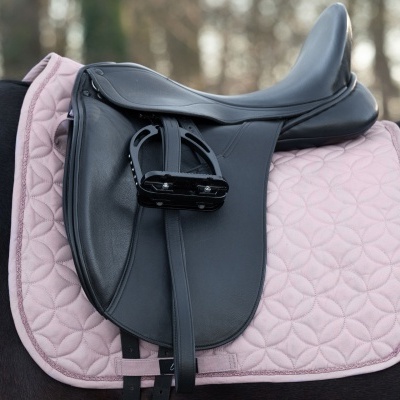 Sela de equitação preta de couro sobre cavalo com manta rosa acolchoada