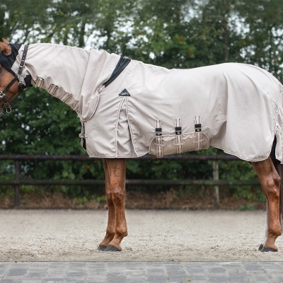 Cavalo com manto branco de tecido com tiras pretas em ambiente externo