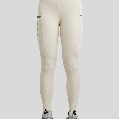 Leggings bege claro com bolsos laterais e logo MONTAR vistas de frente com ténis prateados