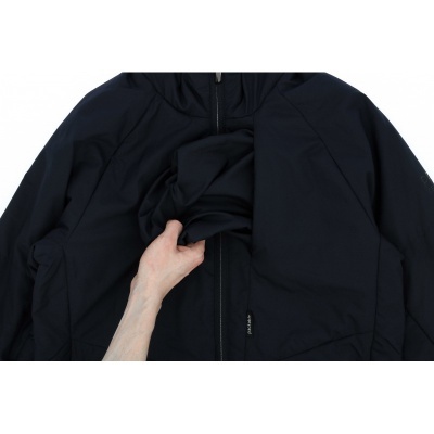 Casaco preto com capuz e fecho de correr, mão segurando o tecido elástico