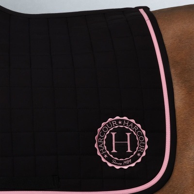 Manta de sela preta com bordas rosa e logo HARCOUR bordado rosa e preto sobre cavalo castanho