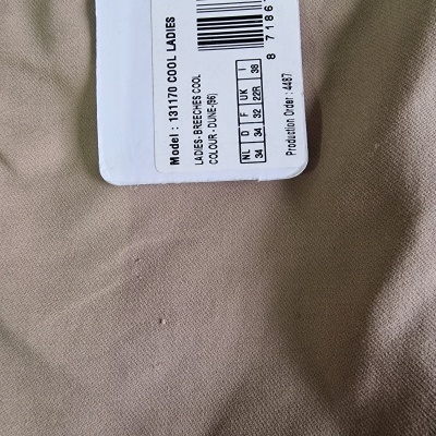 Etiqueta com código de barras e texto preto em tecido castanho claro.