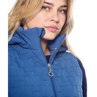 Colete azul com padrão texturizado e fecho éclair prateado, usado por mulher.