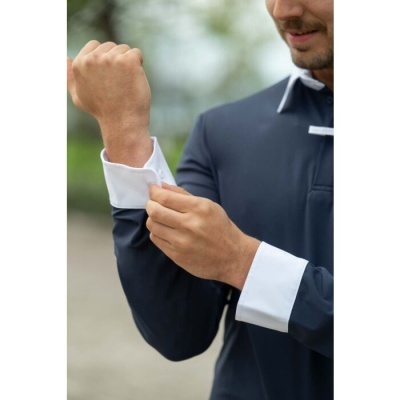 Homem a ajustar punho de camisa azul escuro com punhos brancos