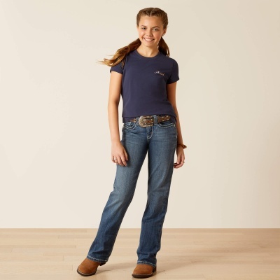Menina com t-shirt azul, calças de ganga, cinto e botas castanhas