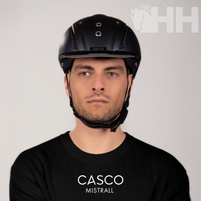 Homem com capacete preto CASCO MISTRALL e camisola preta com texto CASCO MISTRALL