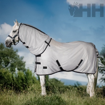 Cavalo branco com manta protectora cinza claro com bordas pretas num campo