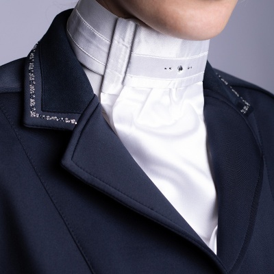 Blazer azul escuro com detalhes brilhantes e camisa branca com gola alta e cristais