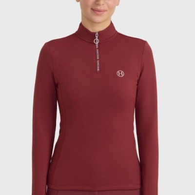 Mulher com casaco vermelho com fecho e boné vermelho com logótipo H, fundo branco