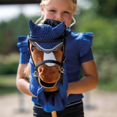 Criança segurando cavalo de pau com proteção azul nas orelhas e rédeas negras