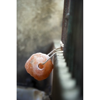 Pedaço de sal de himalaia laranja pendurado numa corda