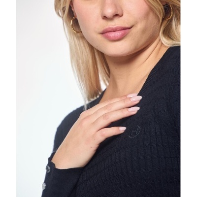 Mulher a usar camisola preta de malha com botões prateados no punho e brincos dourados