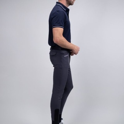 Homem com polo azul escuro, calças cinza justas com reforço preto, e ténis brancos e cinza