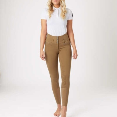 Mulher usa camisa polo branca e calças castanhas justas num fundo branco