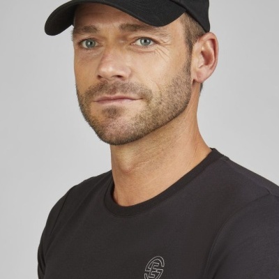 Homem com boné e t-shirt preta com logo branca Eskradrons