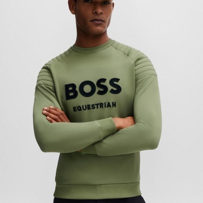 Homem com sweatshirt verde-oliva BOSS EQUESTRIAN e boné verde BOSS