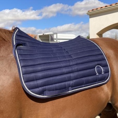 Tapete de sela azul escuro acolchoado com cavalo castanho ao ar livre