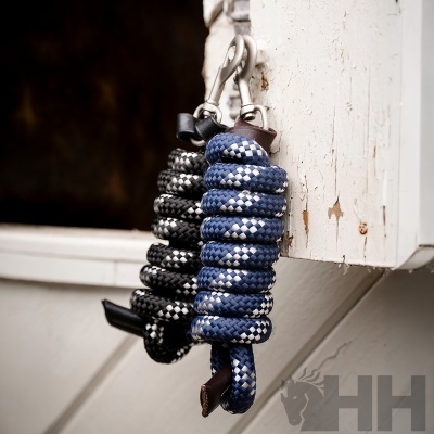 Trela para cão azul e preta enroladas penduradas num gancho