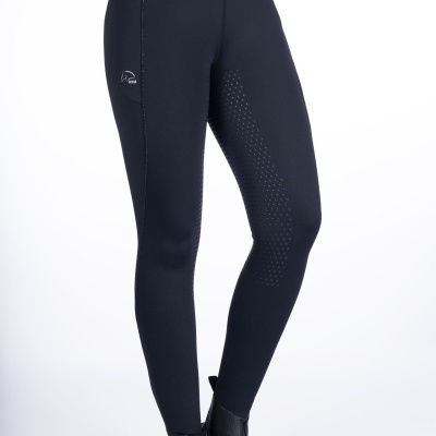 Leggings pretas com detalhe perfurado na perna esquerda e logótipo branco, usadas com botas pretas.