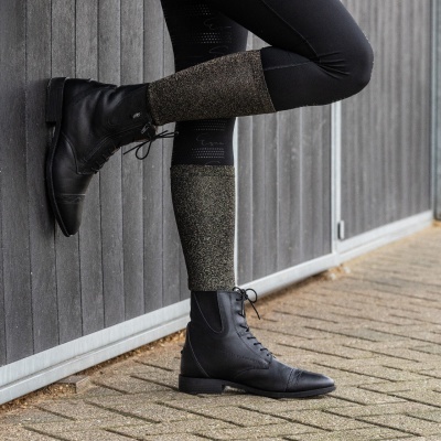 Botas pretas de cano alto com atacadores e polainas cinzentas em ambiente exterior