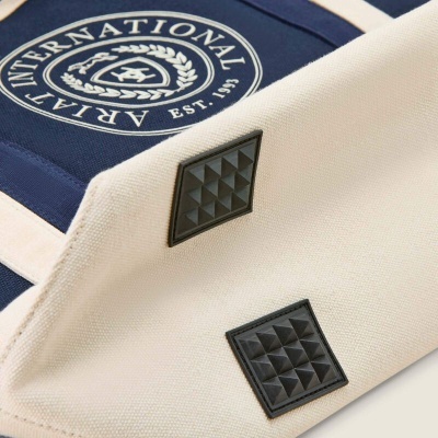 Bolsa creme com selo azul bordado e patches pretos em relevo