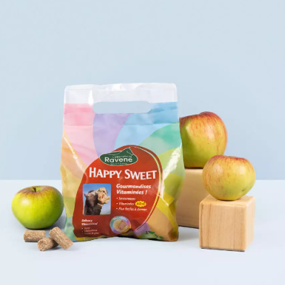 Embalagem colorida de ração para animais e maçãs verdes sobre uma superfície clara.