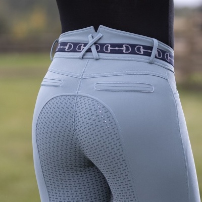 Calças de equitação cinza claro com padrão antiderrapante e cinto cinzento com elos em campo verde