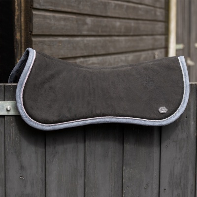 Manta preta para cavalo com bordadura cinza pendurada numa vedação de madeira cinzenta