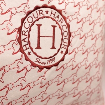 Almofada branca com padrão de cavalos vermelhos e logo bordado HARCOUR