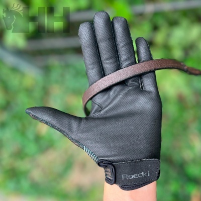 Luva preta Roeckl Sport com correia castanha segurada pela mão
